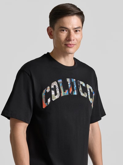 Männermodel trägt T-Shirt mit 1/2-Arm von COLUCCI in Schwarz, reiner Baumwolle, gerader Schnitt, Rundhalsausschnitt, Nahaufnahme Oberkörper.