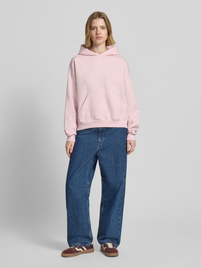 Frauenmodel trägt Regular Fit Hoodie mit Känguru-Tasche Modell 'Iconic' von Gina Tricot, Baumwoll-Mix, elastische Abschlüsse, Ganzkörperansicht von vorne.