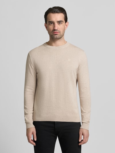 Männermodel trägt Regular Fit Strickpullover aus reiner Baumwolle von Tom Tailor in Beige, unifarben, meliert, Rundhals, Logo-Detail, Ganzkörperansicht von vorne.