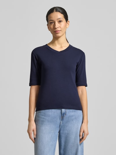 Kobiece modelka nosi T-shirt mit V-Ausschnitt von Christian Berg Woman, mieszanka bawełny i elastanu, krój regular fit, dekolt w serek, rękaw o dł. 1/2, długość tyłu w rozmiarze S: 55 cm, kolor ciemnoniebieski, gładka tekstura, widok całej sylwetki z przodu.
