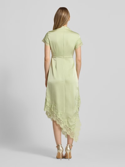 Frauenmodel trägt A-Linie Abendkleid aus Satin Modell 'RITA' von Vero Moda in zartem Grün mit Spitzenbesatz, Ganzkörperansicht Rückansicht. Damen Abendkleid von Vero Moda.