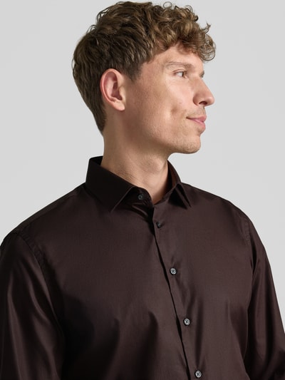 Männermodel trägt Slim Fit Business-Hemd mit Kentkragen von Jake*s aus puur katoen, knoopsluiting, antraciet, gladde textuur, nahaufnahme bovenlichaam. Ruglengte maat 39/40: 79 cm, schouderbreedte: 45 cm, mouwlengte: 67 cm.