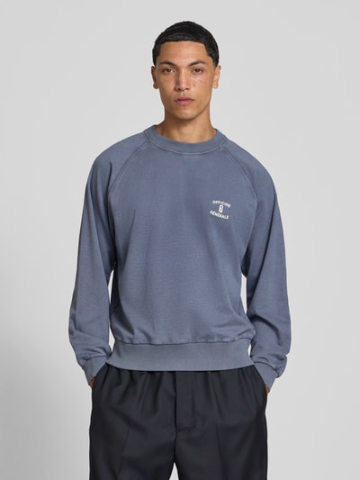 Männermodel trägt Sweatshirt aus reiner Baumwolle von Officine Générale in Blau mit Rundhalsausschnitt, lockere Passform, Ganzkörperansicht von vorne.