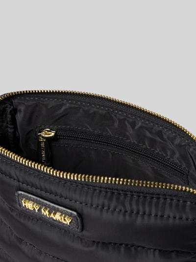 Produktfoto, schwarze Stepp-Tasche mit Logo-Detail Modell 'Little Buddy' von Hey Marly, goldener Reißverschluss, Stepp-Optik, Damen Stepp-Tasche, Hauptfach mit Reißverschluss, Nahaufnahme Innenansicht