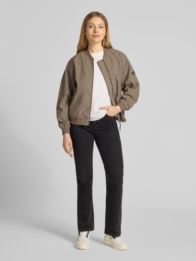 Frauenmodel trägt Jacke mit Pattentaschen Modell 'FACEE' von khujo in Taupe, Regular Fit, Stehkragen, schwarze Hose, Ganzkörperansicht von vorne