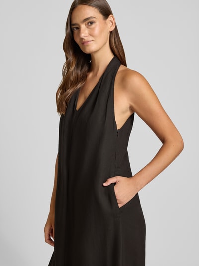 Frauenmodel trägt Midikleid aus Viskose-Mix mit Neckholder Modell 'Qudia' von Someday, Schwarz, Loose-Fit, V-Ausschnitt, Nahaufnahme Oberkörper. Rückenlänge bei Größe 36: 116 cm, Brustweite: 48 cm, Leinen-Viskose-Anteil, seitlicher Nahtreißverschluss.