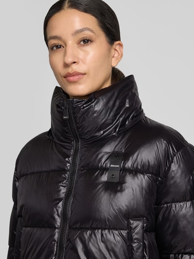 Frauenmodel trägt Regular Fit Jacke mit Sorona-Füllung Modell 'GLORIA' von Blauer USA in Schwarz, Stepp-Optik, Nahaufnahme Oberkörper.
