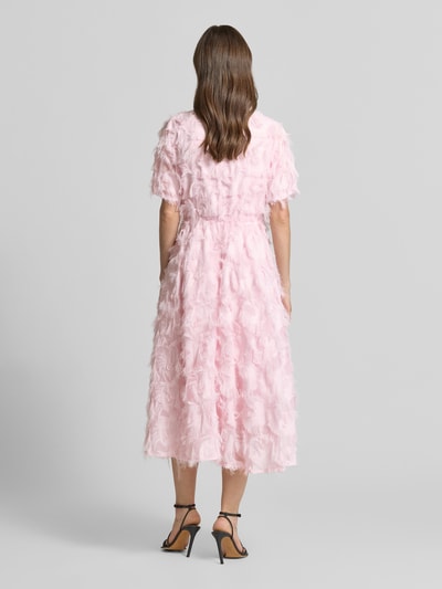 Kobiece model prezentuje różowe, ażurowe cocktailkleid mit fransen Modell 'PAZYLLA' od YAS, fason A-linia, midi, v-dekolt, długość tyłu w rozmiarze 36: 125 cm, szerokość w rozmiarze 36: 43 cm, długość rękawa w rozmiarze 36: 28 cm, widok całej sylwetki z tyłu.