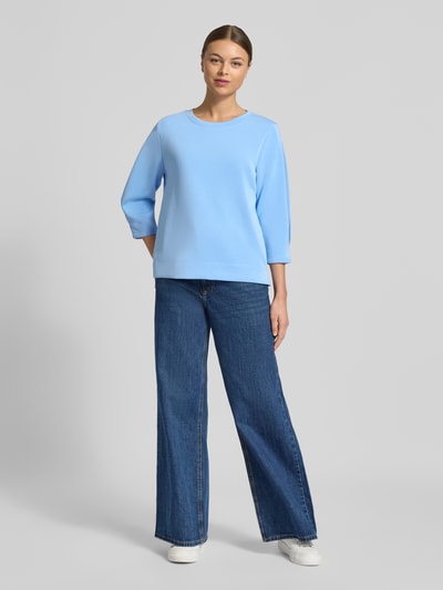 Frauenmodel trägt Comfort Fit Sweatshirt aus Modal-Mix von s.Oliver RED LABEL in Hellblau, unifarben, Rundhals, 3/4-Arm, Ganzkörperansicht von vorne.