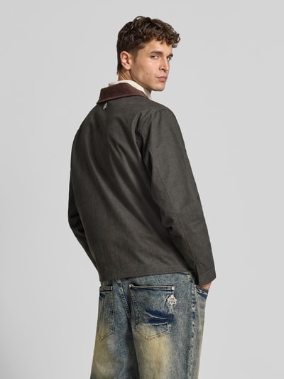 Männermodel trägt Jacke aus reiner Baumwolle von Don’t Waste Culture, dunkel, Kontrastkragen, gerade Passform, Ganzkörperansicht Rückansicht.