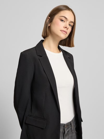 Vrouwenmodel draagt Blazer met Reverskraag Model 'Bossy' van PIECES in zwart, materiaalmix met stretch, klepzakken, los model, voering. Nahaufnahme Oberkörper.