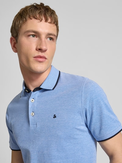 Männermodel trägt Slim Fit Poloshirt mit Viskose-Anteil Modell 'Paulos' von JACK & JONES, Baumwoll-Mix, Logo-Stitching, Nahaufnahme Oberkörper.