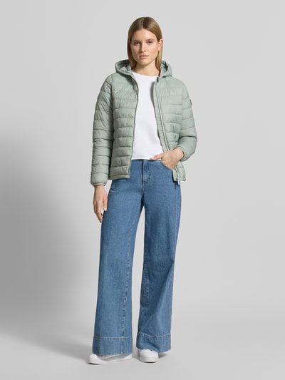 Vrouwenmodel draagt gewatteerd jack met capuchon model 'THELMA' van CARS JEANS, regular fit, ritssluiting, steekzakken, lichtgroen, volledige lichaamsweergave voorkant, ruglengte maat S 61 cm, schouderbreedte 39 cm, borstwijdte 50 cm, mouwlengte 62 cm.