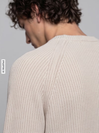 Mężczyzna nosi sweter z bawełny Regular Fit Pullover aus reiner Baumwolle Modell 'BRAUN' od Selected, kremowy kolor, faktura dzianiny, detal ramienia, kontekst: Herren Pullover von Selected, detaliczne ujęcie ramienia, KI-modifiziertes Bild.