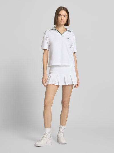 Modelka nosi Regular Fit Sportrock mit Logo-Stitching Modell 'Ski' od adidas Sportswear, czysta bawełna, krój regular fit, fałdowana struktura, zintegrowane szorty, biała, widok całej sylwetki z przodu. Szerokość w rozmiarze S: 37 cm, długość całkowita w rozmiarze S: 29 cm.