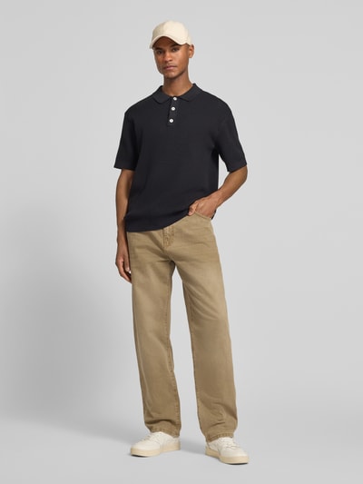 Männermodel trägt schwarzes Regular Fit Poloshirt mit Label-Detail Modell 'ISAKSSON' von Casual Friday, reine Baumwolle, Ganzkörperansicht von vorne.