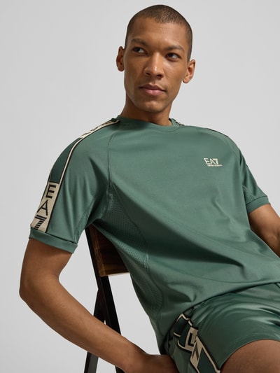 Männermodel trägt T-Shirt aus Viskose-Mix mit Logo von EA7 Emporio Armani, Herren T-Shirt, Regular-Fit, Rundhalsausschnitt, Nahaufnahme Oberkörper.