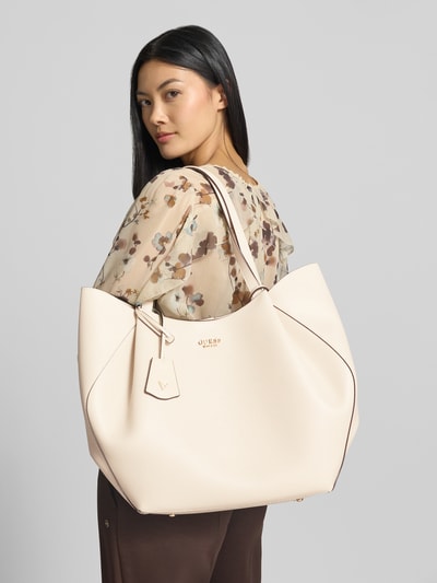 Vrouwenmodel draagt Tote Bag in Leder-Optik Model 'Amorette' van GUESS, logodetail, magneetsluiting, schouderband, Leerlook, zijaanzicht