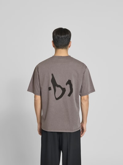 Männermodel trägt T-Shirt mit Logo-Print von WON HUNDRED aus reiner Baumwolle im Relaxed-Fit, braune Farbe, Rückenlänge 71 cm, Ganzkörperansicht Rückansicht.