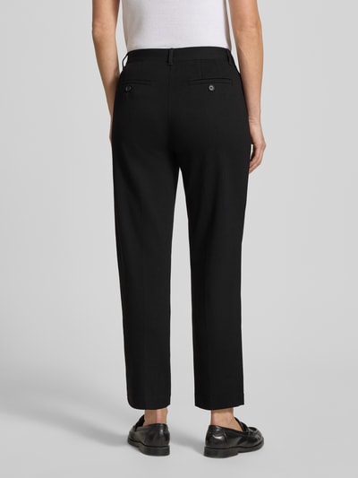 Modelka nosi Chino aus Viskose-Mix mit Gesäßtaschen od Christian Berg Woman, czarne, prosty krój, tylne kieszenie, widok z tyłu całej sylwetki.