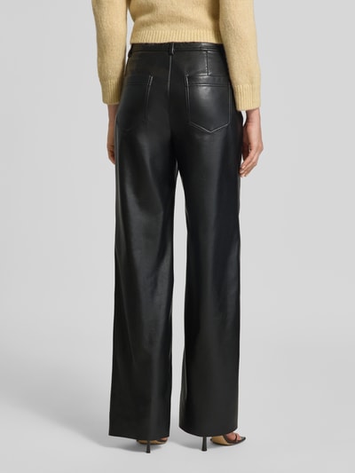 Frauenmodel trägt Straight Fit Hose mit Eingrifftaschen von Marc Cain in Leder-Optik, schwarz, Gürtelschlaufen, Ganzkörperansicht Rückansicht.