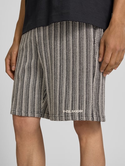 Männermodel trägt Straight Fit Shorts mit Strukturmuster Modell 'Forno' von Pegador aus Reine Baumwolle, Nahaufnahme Oberschenkel.
