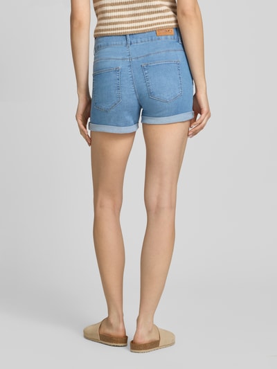 Frauenmodel trägt Regular Fit Jeansshorts aus Baumwoll-Mix Modell 'CARMEN' von Only in Denim-Optik mit Label-Patch und 5-Pocket-Design, Ganzkörperansicht Rückansicht.
