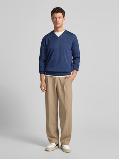 Männermodel draagt Strickpullover aus Schurwolle mit V-Ausschnitt van MAERZ Muenchen in regular fit, blauwe tinten, Ganzkörperansicht von vorne.