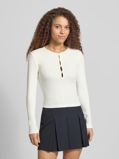 Frauenmodel trägt Slim Fit Langarmshirt aus Baumwoll-Mix Modell 'FEMKE' von Only in Unifarben, Feinripp, Rundhals, Ganzkörperansicht von vorne.