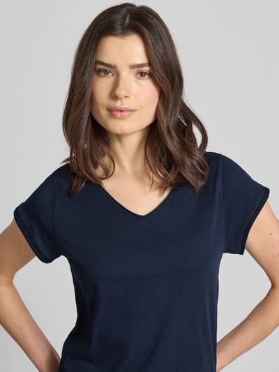 Kobieta nosi damski t-shirt z dekoltem w serek od Christian Berg Woman, bawełna, krój regular fit, zrolowany brzeg, ciemnoniebieski. Zbliżenie na górną część ciała.