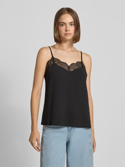 Frauenmodel trägt schwarzes Loose Fit Blusentop mit Spitzenbesatz Model 'TIFFANY' von PIECES, helle Jeans, Ganzkörperansicht von vorne. Damen Blusentop von PIECES.
