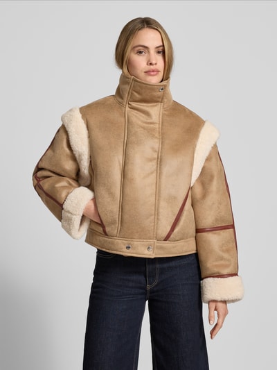 Modelka kobieta nosi Regular Fit Jacke in Lederoptik mit abnehmbaren Ärmeln Modell 'CHEERLEA' od BOSS Orange, brązowa kurtka z białym futerkiem, zamek i napy, boczne kieszenie, widok od frontu, ujęcie całej sylwetki.
