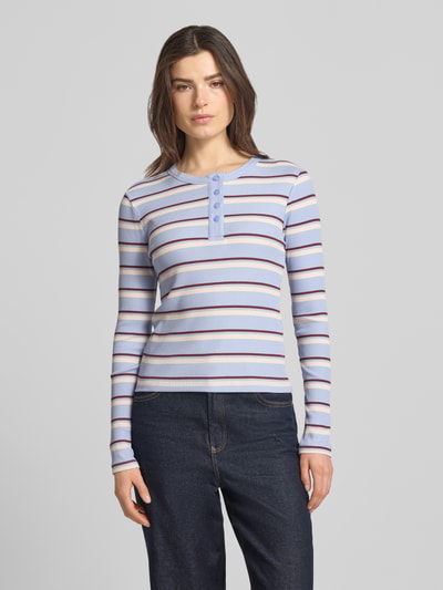Frauenmodel trägt Slim Fit Langarmshirt aus Baumwoll-Mix Modell 'KATIE' von Vero Moda, mehrfarbig gestreift, Feinstrick, Rundhals, Knopfleiste, Ganzkörperansicht von vorne.
