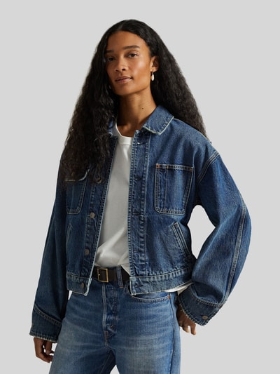 Frauenmodel trägt Relaxed Fit Jeansjacke aus reiner Baumwolle von Polo Ralph Lauren in Denim-Optik mit Umlegekragen, Knopfleiste, Langarm, seitlichen Eingrifftaschen, Brusttaschen; Ganzkörperansicht von vorne.