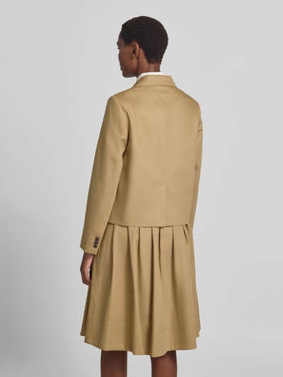 Frauenmodel trägt Regular Fit Kurzblazer aus reiner Baumwolle von Tommy Hilfiger in Beige, glatte Struktur, Ganzkörperansicht Rückansicht.