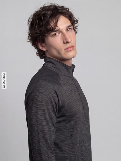 Männermodel trägt Regular Fit Sport-Langarmshirt mit Label-Print von Under Armour in dunklem Grau, Nahaufnahme Oberkörper, KI-modifiziertes Bild.