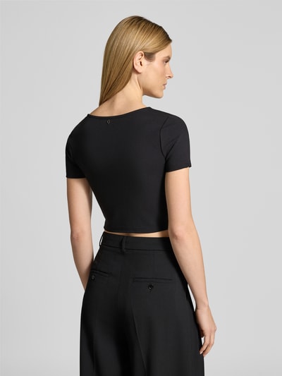 Vrouwenmodel draagt Cropped T-Shirt met Ziersteinbesatz Modell 'Evelina' van Guess, elastische materiaalmix, cropped fit, slim fit, ruglengte 37 cm, zwart, volledig beeld van achteren