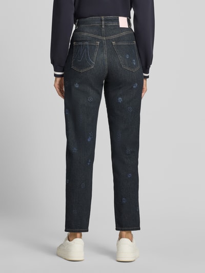 Frauenmodel trägt Straight Fit Jeans aus reiner Baumwolle von Marc Cain mit floralem Allover-Stitching, 5-Pocket-Design, Ganzkörperansicht Rückansicht.