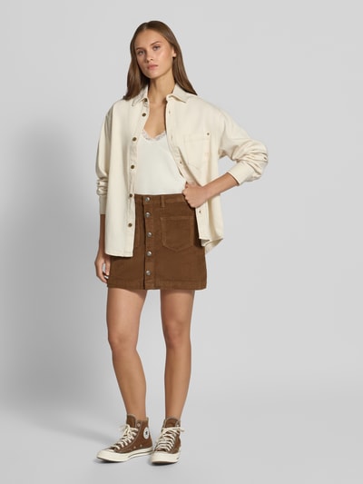 Frauenmodel trägt Eng anliegender Mini-Rock aus Baumwoll-Mix Modell 'AMAZING' von ONLY in Braun mit Knopfleiste, Damen Mini-Rock von ONLY, Ganzkörperansicht von vorne.