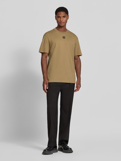 Männermodel trägt Regular Fit T-Shirt aus reiner Baumwolle Modell 'Dalile' von HUGO in Beige, glatte Struktur, Ganzkörperansicht von vorne. Herren T-Shirt von HUGO