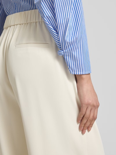 Frauenmodel trägt Stoffhose mit elastischem Bund von Jake*s Collection, cremefarben, Material-Mix mit Stretch, weites Bein, Detailaufnahme Rückansicht.
