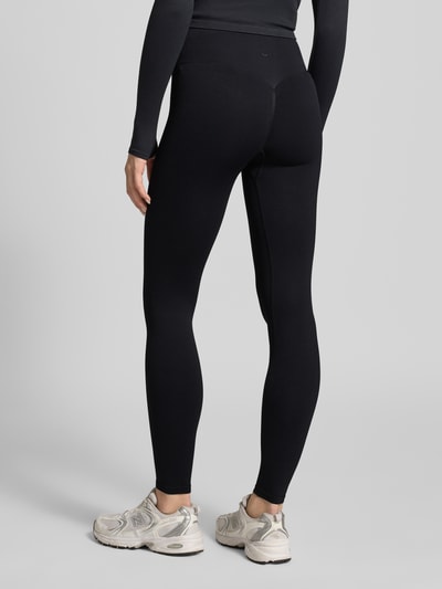 Frauenmodel trägt Leggings mit elastischem Bund von aim'n, schwarze Farbe, Körpernahe Passform, Material-Mix mit Stretch-Anteil, Seamless, Ganzkörperansicht Rückansicht.