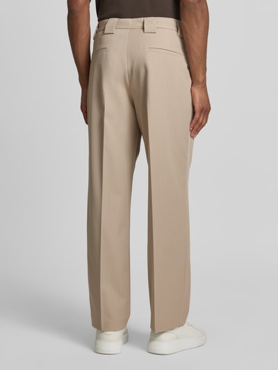 Männermodel trägt Stoffhose mit Bügelfalten und Eingrifftaschen von MCNEAL in Beige, Loose-Fit, Material-Mix mit Viskose-Anteil, Ganzkörperansicht Rückansicht.