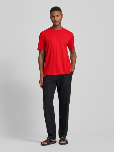 Męski model nosi Regular Fit T-Shirt aus reiner Baumwolle Modell 'DERO222' od HUGO, gładka czerwień, krótki rękaw, dekolt okrągły, nadruk logo, dzianina jersey, przód w pełnej sylwetce.