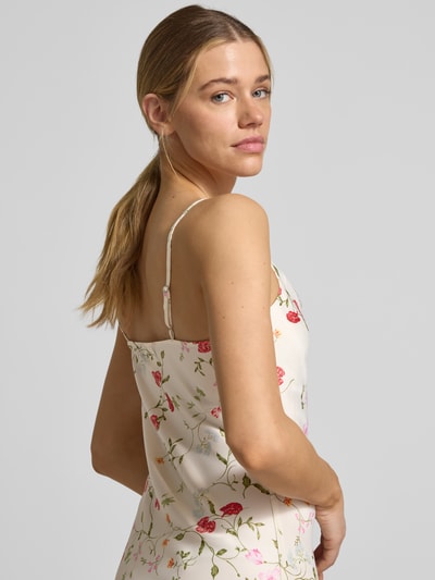 Kobieta modelka nosi kremowe satynowe cocktailkleid mit spaghettiträgern Modell 'THEA' od YAS z kwiatowym wzorem, prosty krój, długość midi, lekki połysk, z bocznym rozcięciem, szerokość w rozmiarze 36: 43 cm, długość pleców 116 cm, nahaufnahme górnej części ciała z przodu.