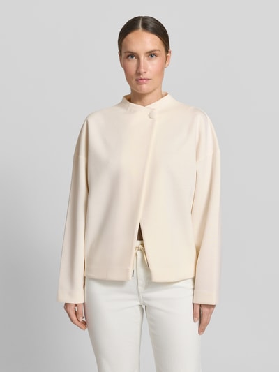 Modelka kobieca ma na sobie Jacke Viskose-Mix mit Knopfverschluss od Rich & Royal w kolorze jasnobeżowym, relaxed fit, stójka, produkt z materiału o gładkiej teksturze, długość tyłu w rozmiarze S: 59 cm, szerokość ramion w rozmiarze S: 55 cm, szerokość klatki piersiowej w rozmiarze S: 51 cm, długość rękawów w rozmiarze S: 62 cm, widok całej sylwetki z przodu.
