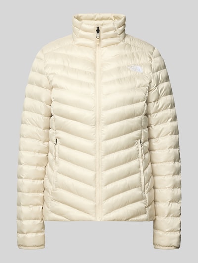 Produktfoto, Steppjacke mit Stehkragen und Label-Stitching von The North Face, krój regular fit, jasny beż, wyhaftowane logo, zamek błyskawiczny, kieszenie zapinane na zamek błyskawiczny, długość tyłu w rozmiarze S: 62 cm, szerokość ramion w rozmiarze S: 38 cm, szerokość w rozmiarze S: 46 cm, długość rękawów w rozmiarze S: 64 cm