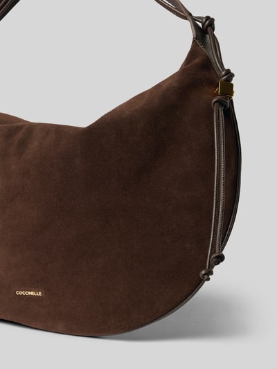 Produktfoto, Handtasche aus echtem Leder Modell 'THESS' von Coccinelle in Dunkelbraun, samtige Textur, goldene Label-Details, Nahaufnahme