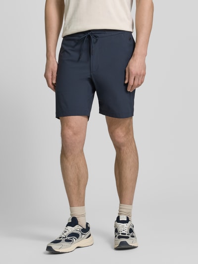 Männermodel trägt Straight Fit Shorts mit Eingrifftaschen Modell 'Drift' von SCANDINAVIAN EDITION, dunkelblau, elastischer Material-Mix, Ganzkörperansicht von vorne