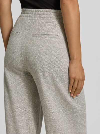 Frauenmodel trägt Hose mit Gesäßtaschen Modell 'FAE' von Drykorn, meliert grauer Material-Mix mit Viskose, Nahaufnahme Rückansicht.